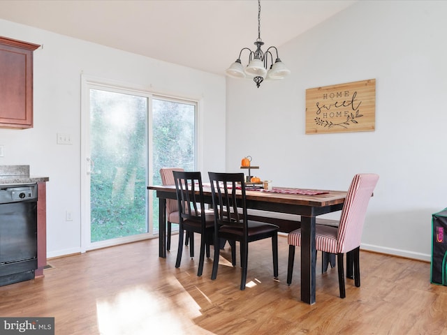 dining area with a chandelier, light hardwood / wood-style floors, and vaulted ceiling