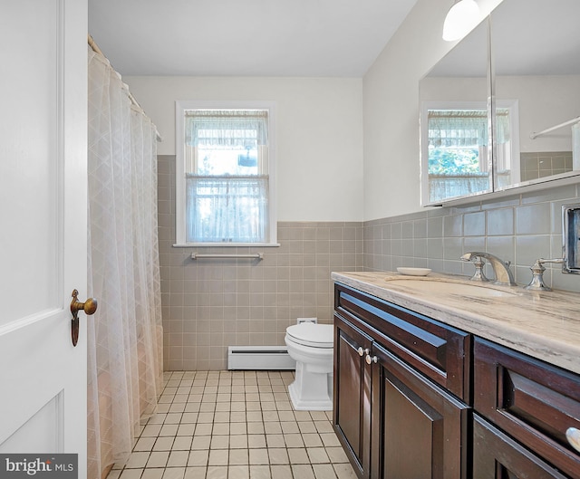 bathroom with vanity, baseboard heating, tile patterned floors, and tile walls