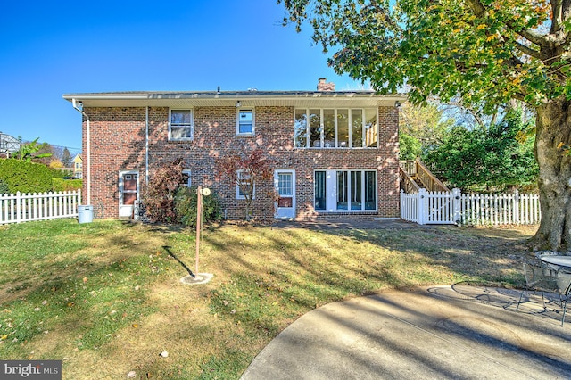 rear view of house featuring a lawn