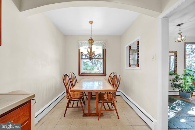 dining area with a baseboard heating unit and a notable chandelier