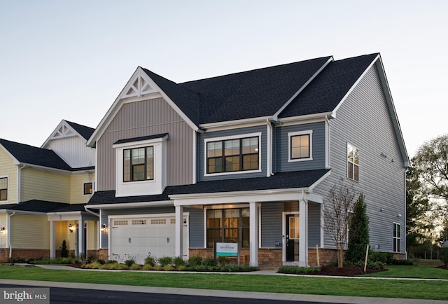 view of front facade with a front yard, a porch, and a garage