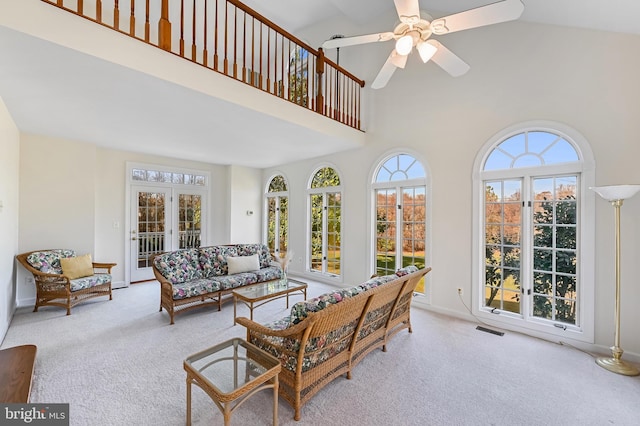 carpeted living room featuring a wealth of natural light, ceiling fan, high vaulted ceiling, and french doors