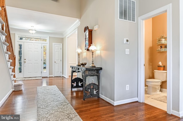 foyer entrance featuring hardwood / wood-style floors and crown molding