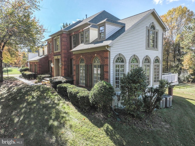 view of side of property with central air condition unit and a yard