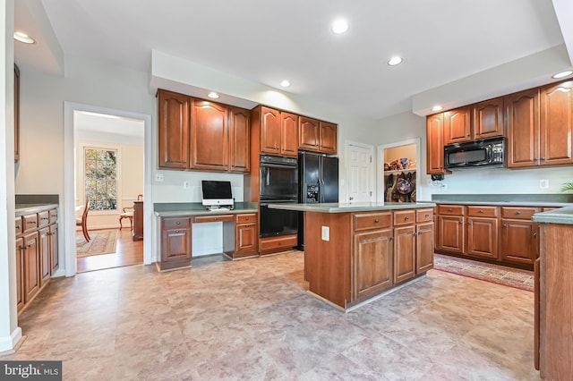 kitchen featuring black appliances, a center island, and built in desk