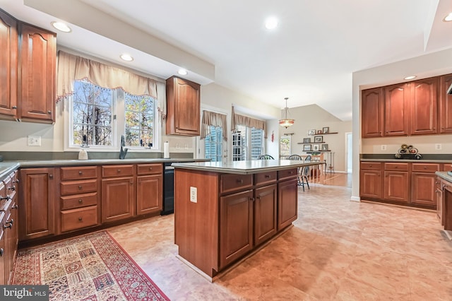 kitchen with decorative light fixtures, dishwasher, sink, and a kitchen island