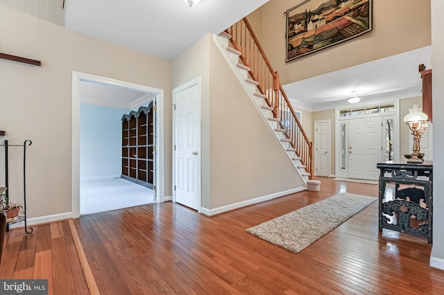 foyer entrance featuring hardwood / wood-style floors and crown molding