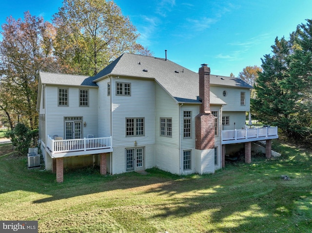 rear view of house with a wooden deck and a yard