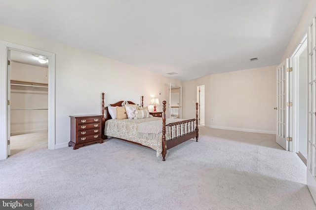 carpeted bedroom featuring a spacious closet and a closet