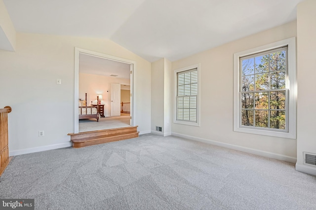 unfurnished living room with carpet flooring and vaulted ceiling