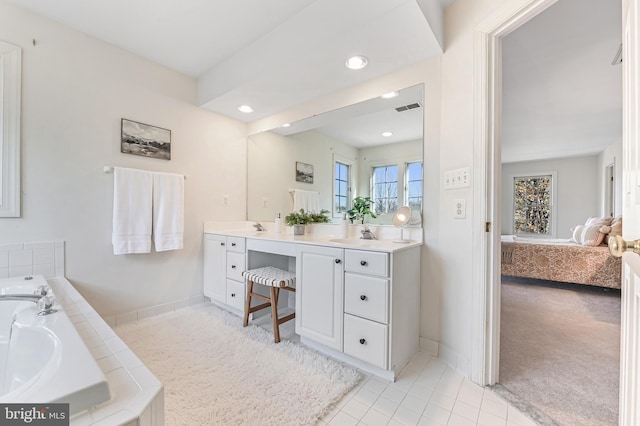 bathroom with tile patterned flooring, vanity, and a tub