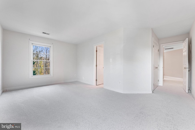 spare room featuring light carpet