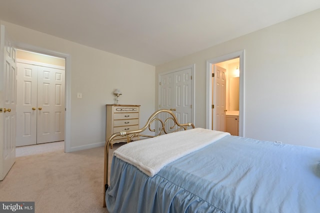 carpeted bedroom featuring ensuite bath