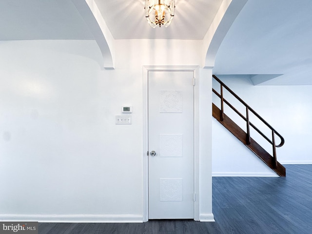 entryway with dark hardwood / wood-style flooring and a notable chandelier