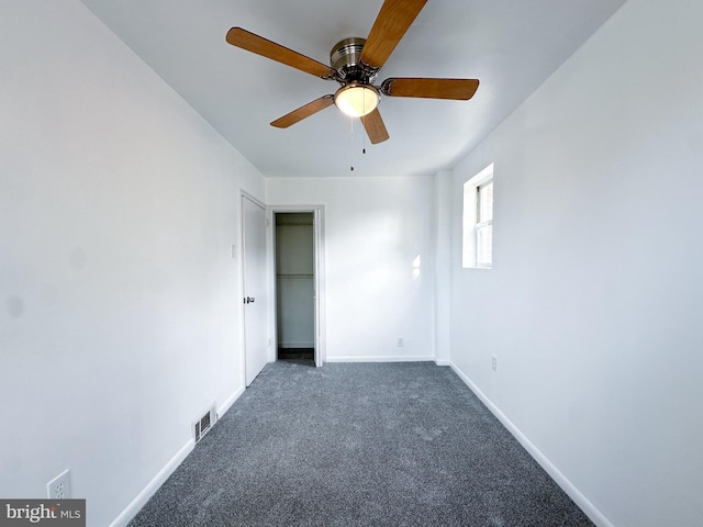 unfurnished bedroom with a closet, dark carpet, and ceiling fan