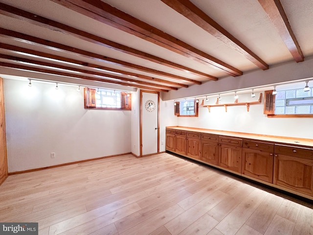 basement with track lighting and light wood-type flooring