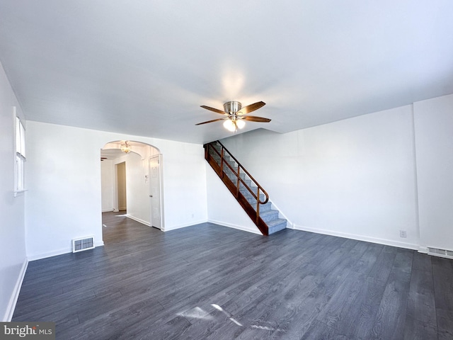 unfurnished living room featuring ceiling fan and dark wood-type flooring