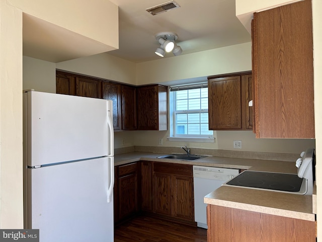 kitchen featuring dark hardwood / wood-style flooring, white appliances, and sink