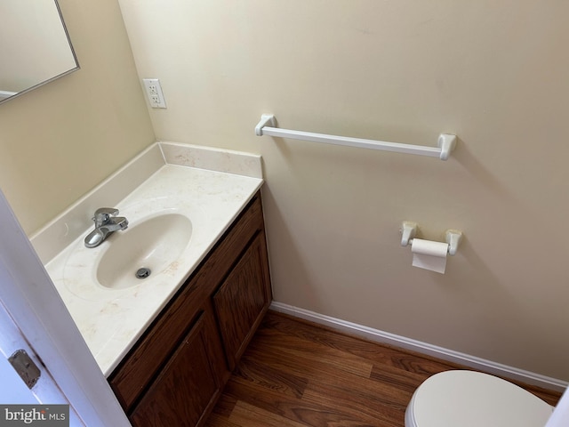 bathroom with vanity, toilet, and wood-type flooring