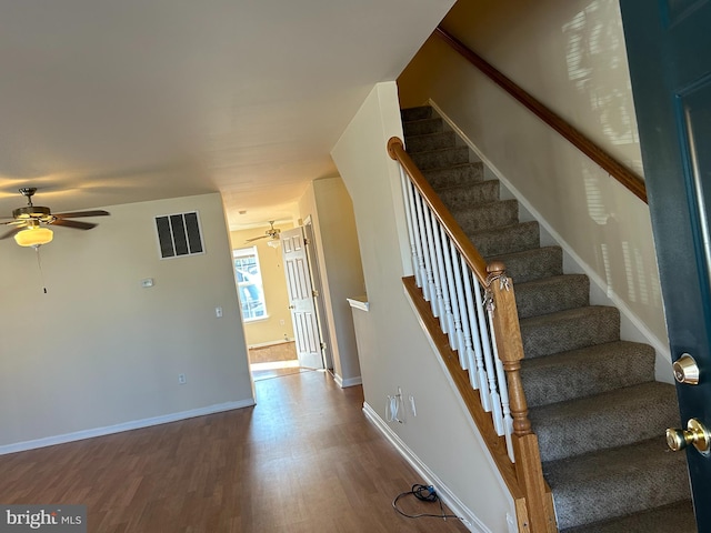 staircase with hardwood / wood-style flooring and ceiling fan