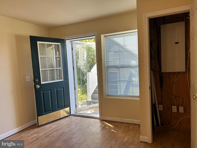 doorway to outside with electric panel and light hardwood / wood-style flooring