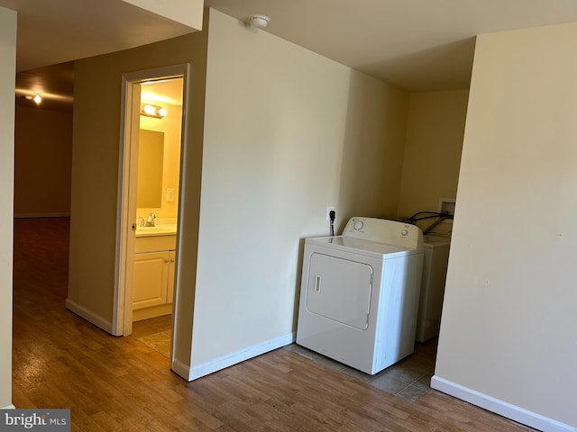 washroom featuring washer / clothes dryer, sink, and wood-type flooring