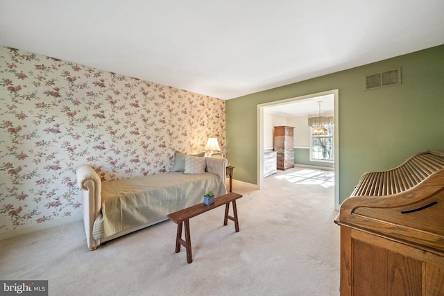 carpeted bedroom featuring an inviting chandelier