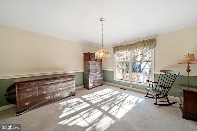 sitting room featuring light colored carpet, an inviting chandelier, and ornamental molding