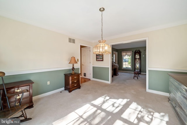 sitting room with a chandelier, light colored carpet, and crown molding