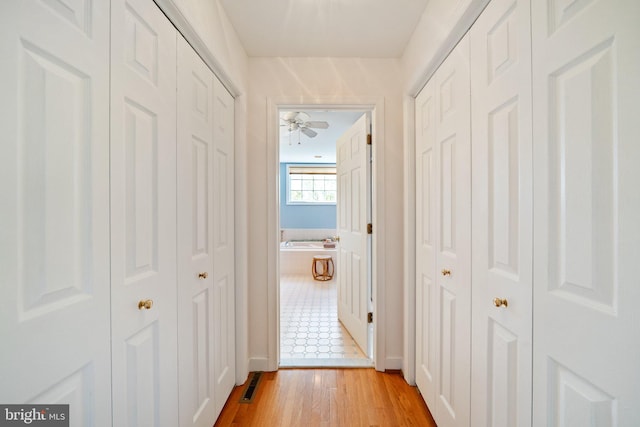 corridor with light hardwood / wood-style flooring