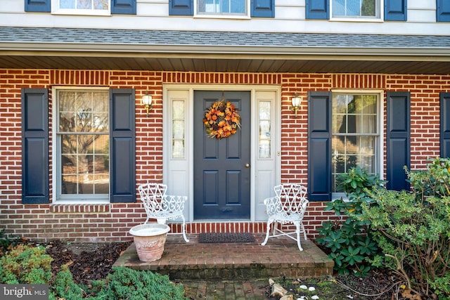 view of exterior entry featuring covered porch