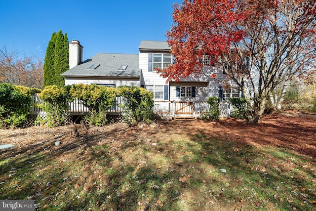 back of house featuring a yard and a deck