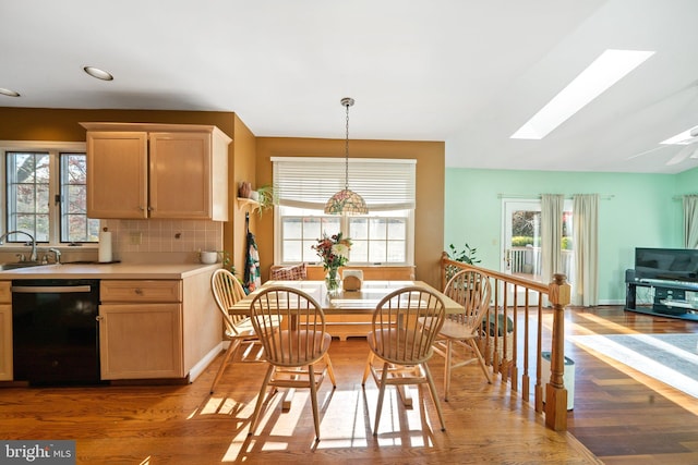 kitchen featuring a skylight, black dishwasher, and plenty of natural light