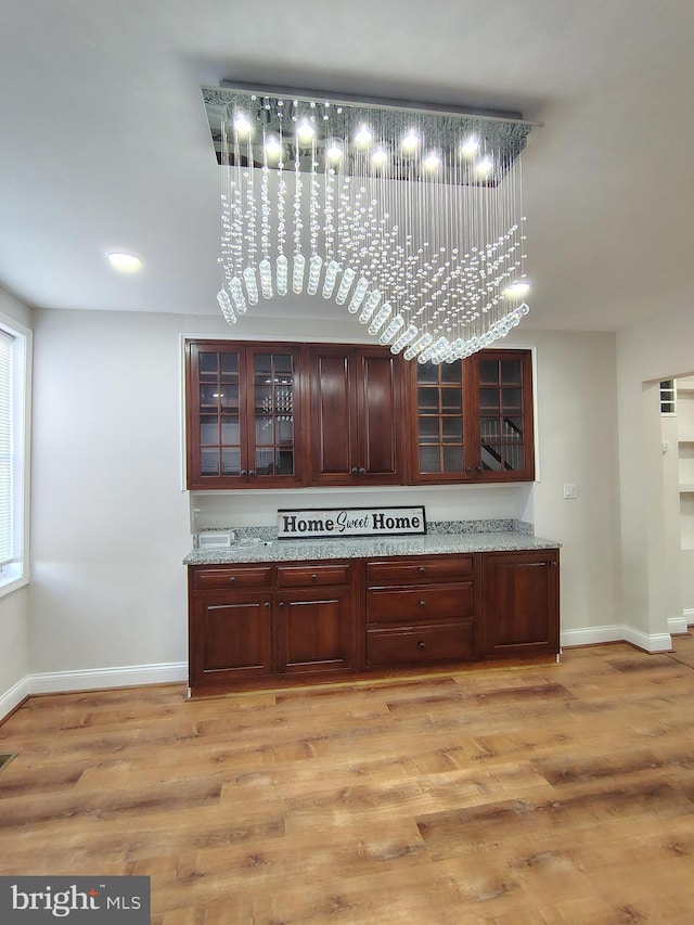 bar with visible vents, light wood-style flooring, and baseboards