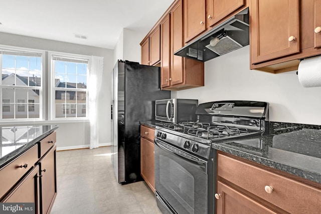 kitchen with black gas stove and dark stone counters