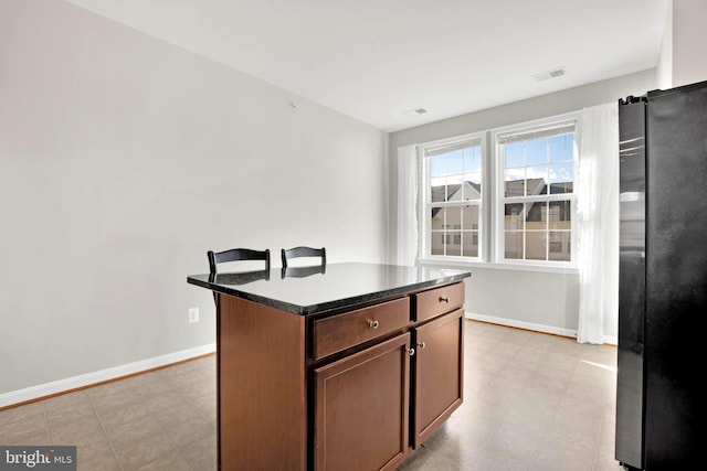 kitchen with stainless steel fridge and a kitchen island