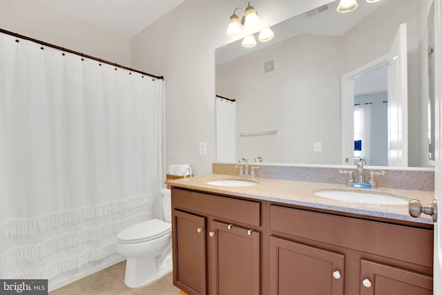 bathroom with tile patterned flooring, vanity, and toilet