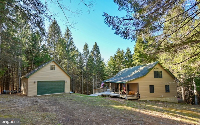 exterior space with a garage, an outdoor structure, and a deck