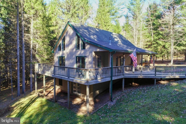 back of property featuring a lawn and a deck