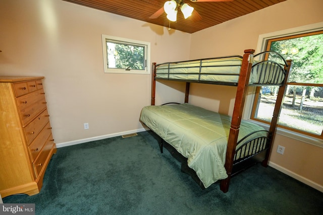 bedroom featuring ceiling fan, wood ceiling, and dark colored carpet