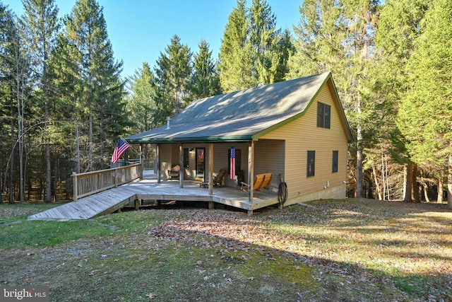 rear view of property featuring a lawn and a deck