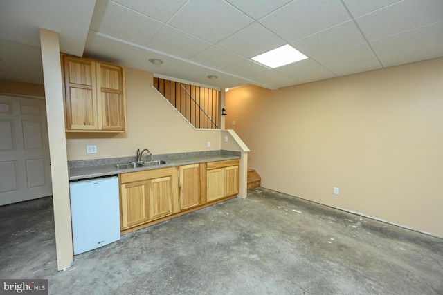 kitchen with a paneled ceiling, sink, white dishwasher, and light brown cabinets