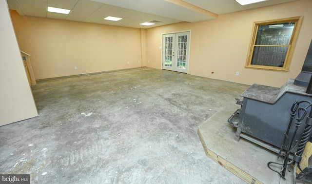 interior space featuring concrete flooring, french doors, and a wood stove