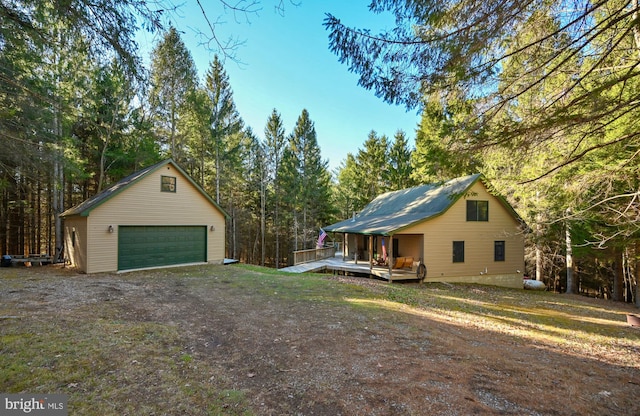 view of yard with a garage, an outdoor structure, and a wooden deck