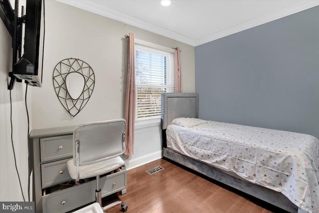 bedroom with ornamental molding and dark hardwood / wood-style floors