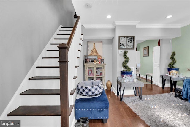 stairway featuring hardwood / wood-style floors and crown molding