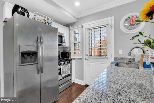 kitchen featuring light stone counters, ornamental molding, appliances with stainless steel finishes, sink, and dark wood-type flooring