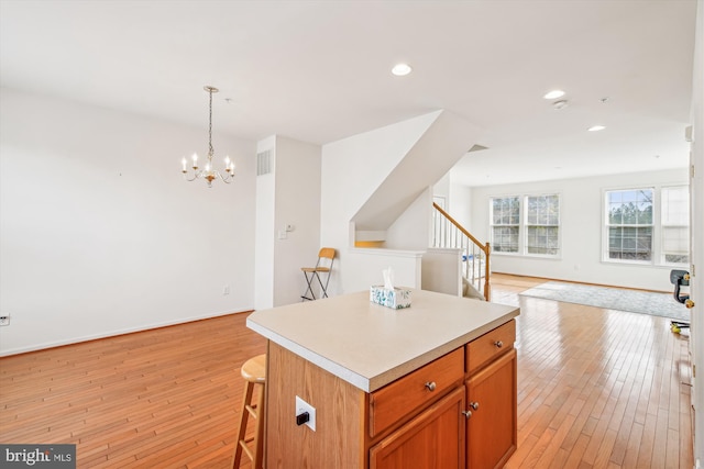 kitchen featuring a chandelier, a center island, hanging light fixtures, and light hardwood / wood-style floors