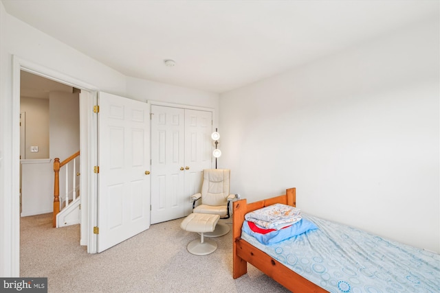 bedroom featuring light colored carpet and a closet