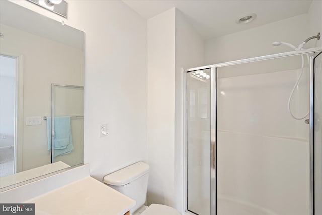 bathroom featuring vanity, an enclosed shower, and toilet